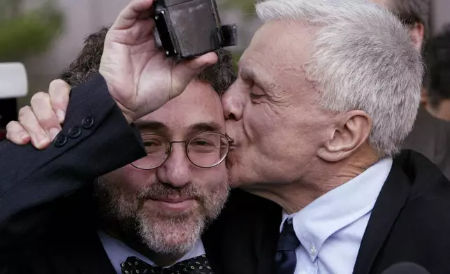 FILE - Robert Blake, right, kisses his attorney M. Gerald Schwartzbach as Schwartzbach holds up Blake's ankle monitor after Blake was found not guilty in his murder trial for the death of his wife, Bonny Lee Bakley, in Los Angeles, March 16, 2005. (AP Photo/Nick Ut, File)