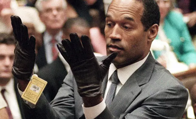 FILE - O.J. Simpson holds up his hands before the jury after putting on a new pair of gloves similar to the infamous bloody gloves, during his double-murder trial in Los Angeles, June 21, 1995. (Vince Bucci/Pool Photo via AP, File)