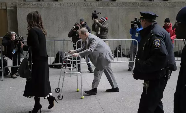 FILE - Reporters look on as Harvey Weinstein, center, arrives to court after a break on the first day of jury selection of his sexual assault trial, in New York, Jan. 7, 2020. (AP Photo/Seth Wenig, File)