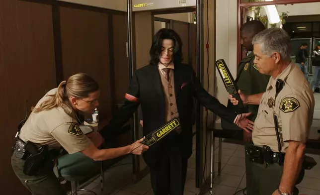 FILE - Sheriff deputies scan Michael Jackson with metal detectors as he passes through a security checkpoint upon arriving for his child molestation trial at the Santa Barbara County Courthouse in Santa Maria., Calif., on May 18, 2005. (AP Photo/Eric Neitzel/WireImage File)