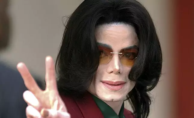 FILE - Pop star Michael Jackson acknowledges his fans as he arrives at the Santa Barbara County Courthouse, in Santa Maria, Calif., March 17, 2005. Jackson was acquitted in 2005 of molesting a 13-year-old cancer survivor at his Neverland Ranch. (AP Photo/Michael A. Mariant, File)