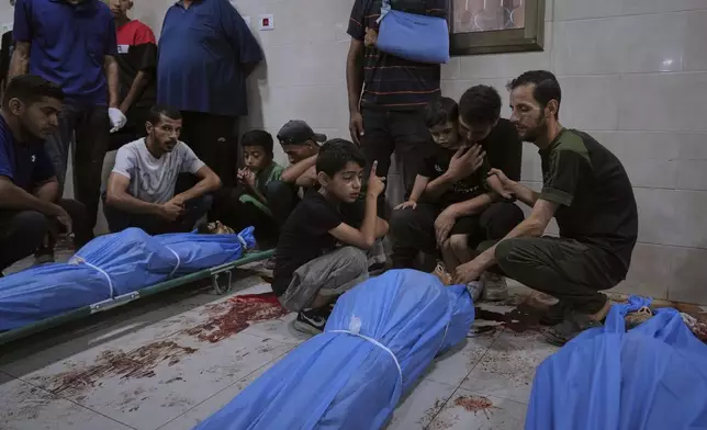 Mourners attend the funeral of victims who were killed in an Israeli bombardment of Gaza Strip, at the Al-Awda Hospital in Nuseirat, on Tuesday, July 8, 2025. (AP Photo/Abdel Kareem Hana)