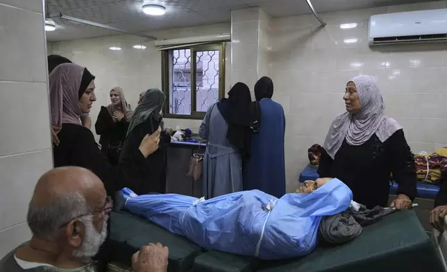 Mourners carry the body of Ahmed Abu Hayya, 63, who was killed in an Israeli bombardment of Gaza Strip, at the Al-Awda Hospital in Nuseirat, on Tuesday, July 8, 2025. (AP Photo/Abdel Kareem Hana)