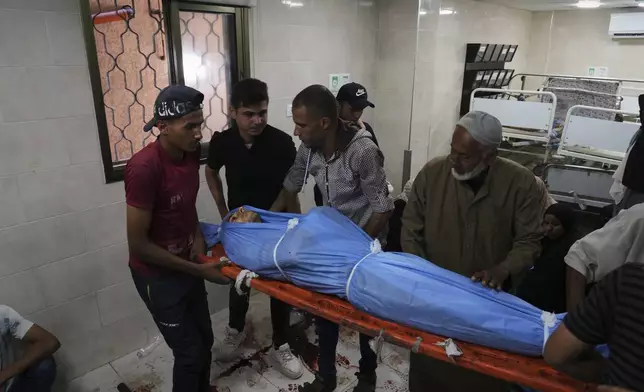 Mourners carry the body of Ahmed Radi who was killed in an Israeli bombardment of Gaza Strip, at the Al-Awda Hospital in Nuseirat, on Tuesday, July 8, 2025. (AP Photo/Abdel Kareem Hana)