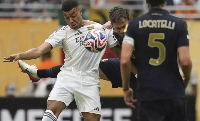 Real Madrid's Kylian Mbappe, left, and Juventus' Daniele Rugani challenge for the ball during the Club World Cup round of 16 soccer match between Real Madrid and Juventus in Miami Gardens, Fla., Tuesday, July 1, 2025. (AP Photo/Lynne Sladky)
