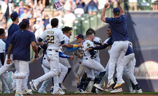 Milwaukee Brewers' Caleb Durbin (21) celebrates with teammates after driving in the winning run with a walk off single in the ninth inning of a baseball game against the Washington Nationals, Saturday, July 12, 2025, in Milwaukee. (AP Photo/Aaron Gash)