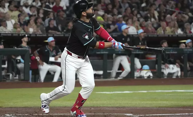 Arizona Diamondbacks' Eugenio Suárez hits an RBI sacrifice flyout in the first inning during a baseball game against the Kansas City Royals, Friday, July 4, 2025, in Phoenix. (AP Photo/Rick Scuteri)