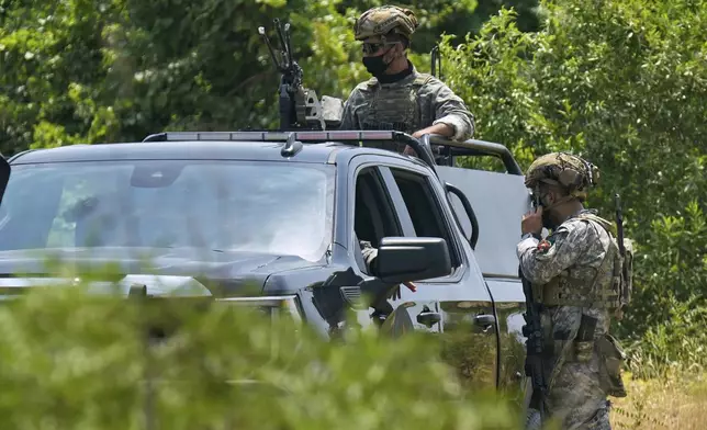 Forces of the regional Kurdish administration secure the area of the Jasana Cave ahead of a symbolic disarmament ceremony by the separatist PKK group as part of the peace process with Turkey, in Sulaymaniyah governorate, Iraq, Friday, July 11, 2025. (AP Photo/Hadi Mizban)