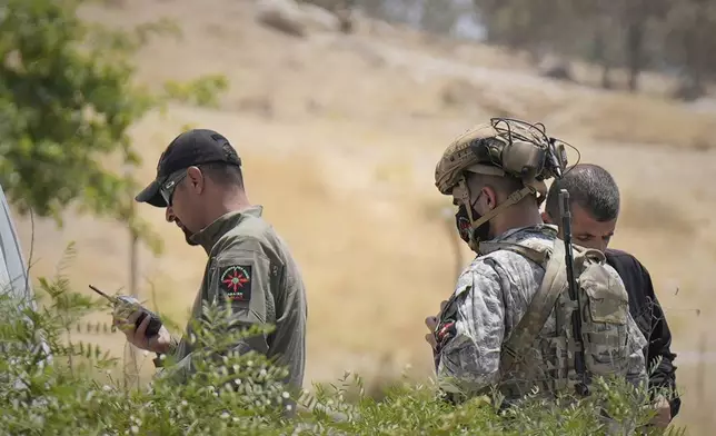 Forces of the regional Kurdish administration secure the area of the Jasana Cave ahead of a symbolic disarmament ceremony by the separatist PKK group as part of the peace process with Turkey, in Sulaymaniyah governorate, Iraq, Friday, July 11, 2025. (AP Photo/Hadi Mizban)