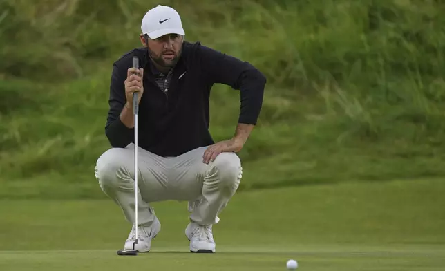 Scottie Scheffler of the United States lines up his putt on the 18th green during the third round of the British Open golf championship at the Royal Portrush Golf Club, Northern Ireland, Saturday, July 19, 2025. (AP Photo/Francisco Seco)