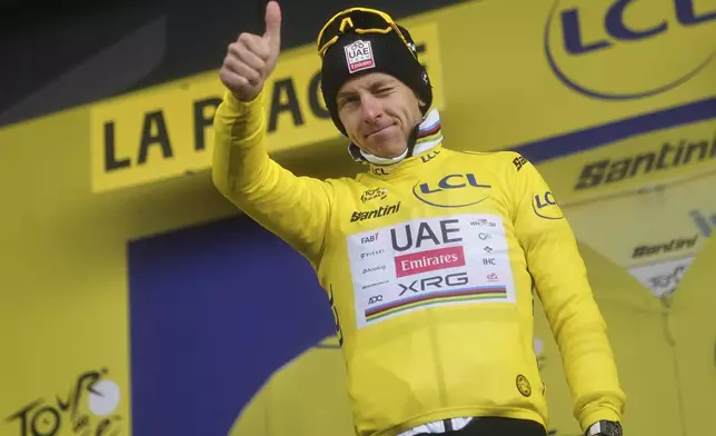 Slovenia's Tadej Pogacar, wearing the overall leader's yellow jersey, celebrates on the podium after the nineteenth stage of the Tour de France cycling race over 93.1 kilometers (57.85 miles) with start in Albertville and finish in La Plagne, France, Friday, July 25, 2025. (AP Photo/Thibault Camus)