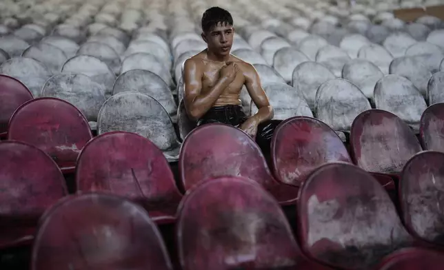 A young wrestler rests after a round during the 663rd annual Historic Kirkpinar Oil Wrestling championship, in Edirne, northwestern Turkey, Sunday, July 6, 2025.(AP Photo/Khalil Hamra)