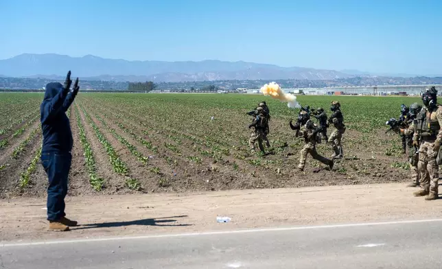 Federal immigration agents toss tear gas at protesters during a raid in the agriculture area of Camarillo, Calif., Thursday, July 10, 2025. (AP Photo/Michael Owen Baker)