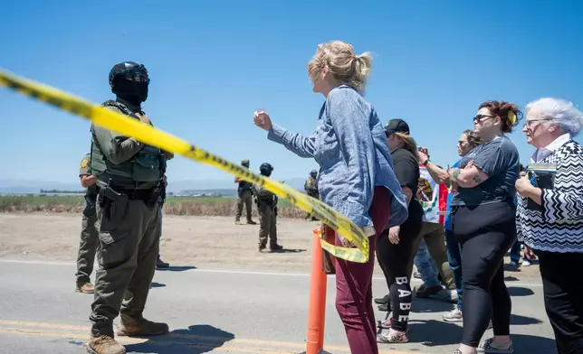 People shout at federal immigration agents during a raid in the agriculture area of Camarillo, Calif., Thursday, July 10, 2025. (AP Photo/Michael Owen Baker)