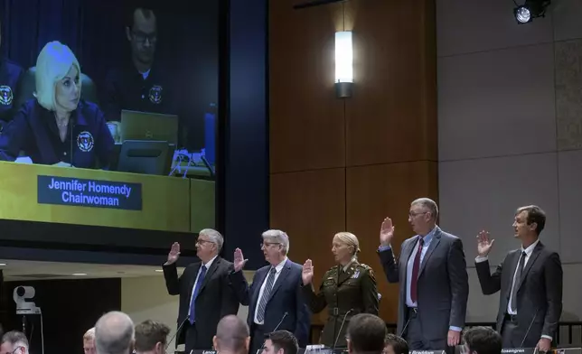 National Transportation Safety Board Chairwoman Jennifer Homendy, on monitor left, swears-in the witnesses from left: Dan Cooper, Sikorsky Aircraft, Lance Gant, Federal Aviation Administration, U.S. Army CW4 Kylene Lewis, Steve Braddom, U.S. Army, and Scott Rosengren, U.S. Army, during the NTSB fact-finding hearing on the DCA midair collision accident, at the National Transportation and Safety Board boardroom, Wednesday, July 30, 2025, in Washington. (AP Photo/Rod Lamkey, Jr.)