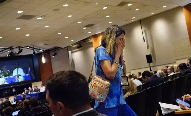 Christina Stovall, whose husband, Mikey Stovall, died on American Airlines flight 5342 in a collision with a U.S. military helicopter, weeps as she leaves the room during the NTSB fact-finding hearing on the DCA midair collision accident, at the National Transportation and Safety Board boardroom, Wednesday, July 30, 2025, in Washington. (AP Photo/Rod Lamkey, Jr.)