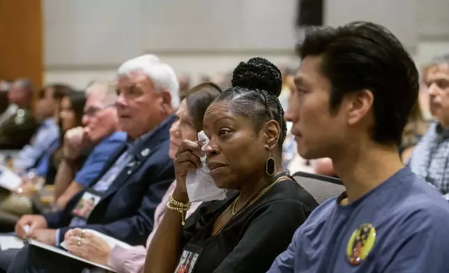 Gwen Duggins, second from right, whose daughter Kiah Duggins perished on American Airlines flight 5342 in a collision with a U.S. military helicopter, wipes the tears from her eyes while listening to the audio of the flight radio transmissions during the NTSB fact-finding hearing on the DCA midair collision accident, at the National Transportation and Safety Board boardroom, Wednesday, July 30, 2025, in Washington. (AP Photo/Rod Lamkey, Jr.)