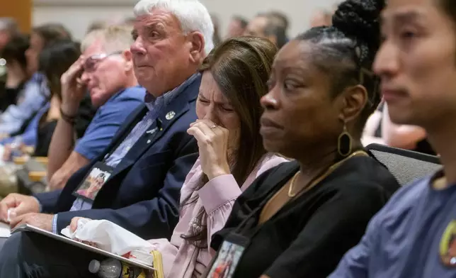 Family members of the victims of American Airlines flight 5342 who perished in a collision with a U.S. military helicopter, react while watching a video of the moment of the crash, during the NTSB fact-finding hearing on the DCA midair collision accident, at the National Transportation and Safety Board boardroom, Wednesday, July 30, 2025, in Washington. (AP Photo/Rod Lamkey, Jr.)