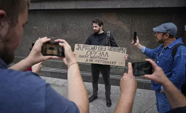 An activist holds a sign reading, "For Russia without censorship. Orwell wrote a dystopia, not an instruction manual,” referring to author George Orwell during a protest in front of the State Duma, the lower house of the Russian parliament, in Moscow, Russia, Tuesday, July 22, 2025, prior to lawmakers approving a measure that punishes online searches for information that is deemed “extremist.” (AP Photo)