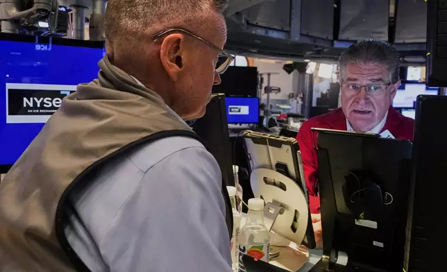 Traders Neil Catania, left, and Daniel Kryger work on the floor of the New York Stock Exchange, Monday, July 21, 2025. (AP Photo/Richard Drew)
