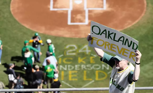 FILE - A fan holds up an "Oakland Forever" sign during the A's last home baseball game at the Oakland Coliseum against the Texas Rangers, Thursday, Sept. 26, 2024, in Oakland, Calif. (AP Photo/Benjamin Fanjoy, File)