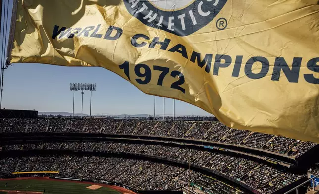 FILE - A 1972 world champions banner flies over the Oakland Coliseum during the Oakland Athletics' last home baseball game at the ballpark against the Texas Rangers in Oakland, Calif., Thursday, Sept. 26, 2024. (Stephen Lam/San Francisco Chronicle via AP, File)