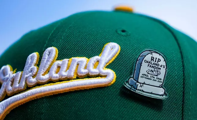 FILE - A fan wears an Oakland Athletics hat with a pin referencing the end of the team's time in Oakland before a baseball game against the Seattle Mariners, Sunday, Sept. 29, 2024, in Seattle. (AP Photo/Lindsey Wasson, File)