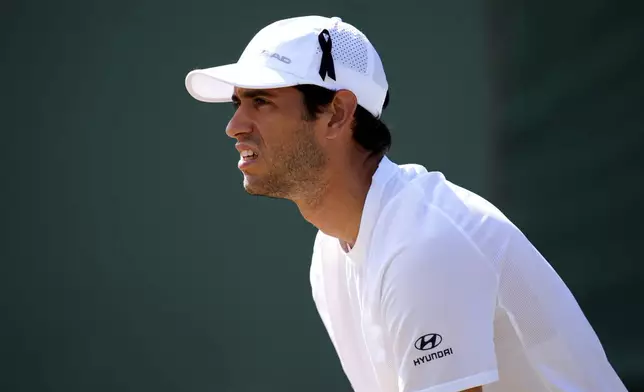 Nuno Borges of Portugal, wearing a black ribbon in his hat in memory of compatriot Diogo Jota, as he plays Karen Khachanov of Russia during their men's singles match on day five of the Wimbledon Tennis Championships in London, Friday July 4, 2025. (Mike Egerton/PA via AP)