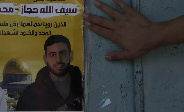 A memorial poster showing Palestinian-American Sayfollah Musallet, who was beaten to death by Israeli settlers, is displayed outside of a bakery in the West Bank town of Al Mazra as-Sharqiya, Monday, July 21, 2025. (AP Photo/Maya Alleruzzo)