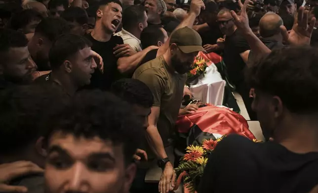 FILE - Mourners carry the bodies of Palestinian-American Sayfollah Musallet and Mohammed al-Shalabi during their funeral in the West Bank village of Al-Mazraa a-Sharqiya on Sunday, July 13, 2025. (AP Photo/Leo Correa, File)