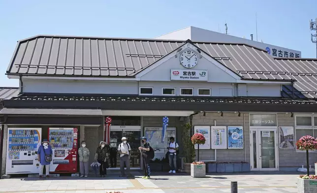 Passengers stand in front of a staion in Miyako, Iwate prefecture, northern Japan Wednesday, July 30, 2025 as train services were suspended due to a tsunami alert following a powerful earthquake in Russia's Far East. (Yohei Kanesashi/Kyodo News via AP)