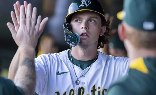 Athletics' Nick Kurtz celebrates in the dugout after scoring during the second inning of a baseball game against the San Francisco Giants Saturday, July 5, 2025, in West Sacramento, Calif. (AP Photo/Sara Nevis)