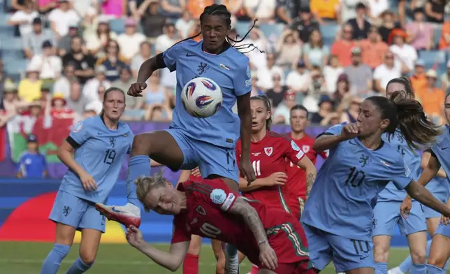 Netherlands' Esmee Brugts, top, clears the ball over Wales' Jess Fishlock during the Euro 2025, group D, soccer match between Wales and the Netherlands at Allmend Stadion Luzern in Lucerne, Switzerland, Saturday, July 5, 2025. (AP Photo/Alessandra Tarantino)
