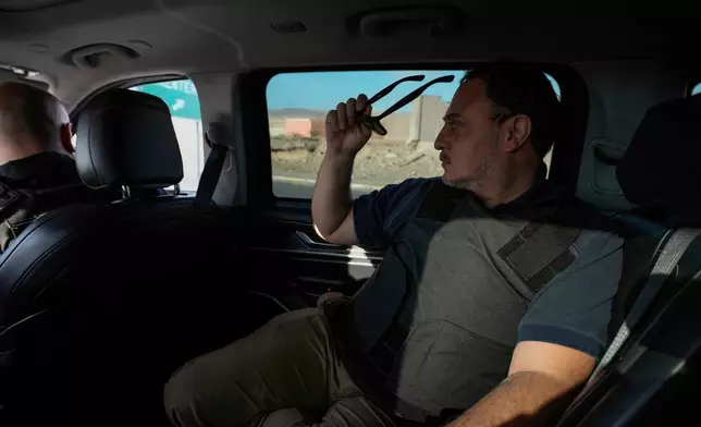 Prosecutor Mario Carrera, wearing an armored vest, surveys the shantytown of Cerro Chuño, a stronghold of Los Gallegos, the northern Chilean offshoot of the Tren de Aragua criminal gang, in Arica, Chile, Sunday, June 8, 2025. (AP Photo/Esteban Felix)