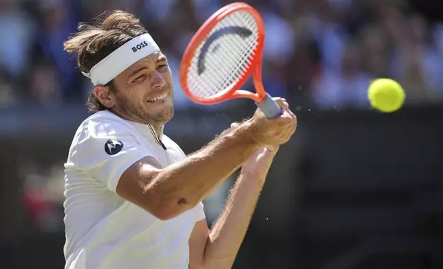 Taylor Fritz of the U.S. returns to Spain's Carlos Alcaraz in a men's singles semifinal at the Wimbledon Tennis Championships in London, Friday, July 11, 2025. (AP Photo/Kin Cheung)