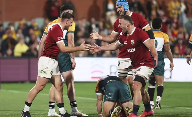 Ben White, left, of the British &amp; Irish Lions is congratulated by teammates after scoring a try during the rugby match between the Lions and the AUNZ Invitational XV in Adelaide, Saturday, July 12, 2025. (AP Photo/James Elsby)