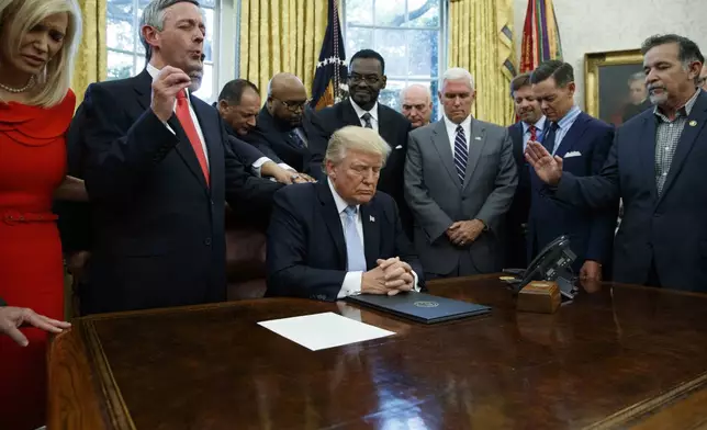 FILE - Religious leaders pray with President Donald Trump Sept. 1, 2017, after he signed a proclamation for a national day of prayer to occur on Sept. 3, 2017, in the Oval Office of the White House in Washington. (AP Photo/Evan Vucci, File)