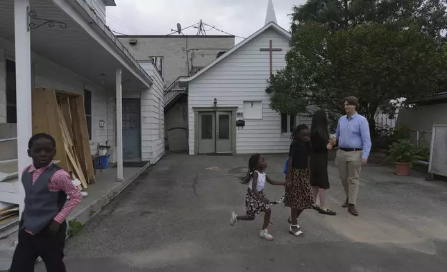Children play while Megane Ares-Dube and her husband, Raphael Lapointe, talk after attending service at the Reformed Baptist Church in Saint Jerome, Quebec, Sunday, June 29, 2025. (AP Photo/Luis Andres Henao)