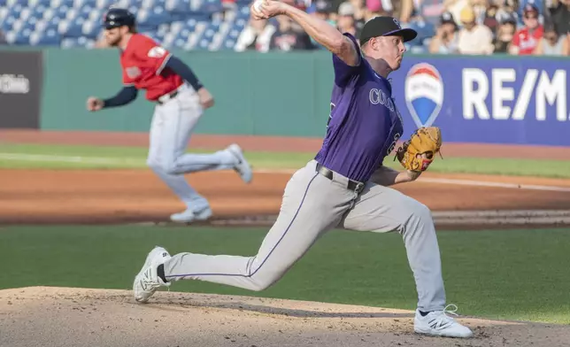 Colorado Rockies starting pitcher Tanner Gordon delivers as Cleveland Guardians' Daniel Schneemann steals second base in the background during the first inning of a baseball game, Tuesday, July 29, 2025, in Cleveland. (AP Photo/Phil Long)