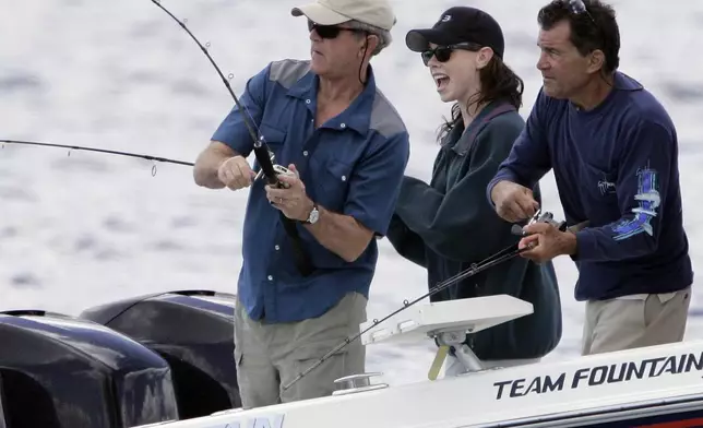 FILE - President George W. Bush, from left, reels in his catch as his daughter Barbara Bush and fishing guide BIlly Bush look on, June 30, 2007, in Kennebunkport, Maine. (AP Photo/Robert F. Bukaty, File)