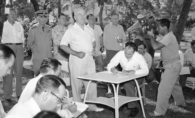 FILE - President Harry Truman holds a vacation press conference surrounded by aides and members of the media on Little White House Lawn in Key West, Fla., March 18, 1949. (AP Photo/File)