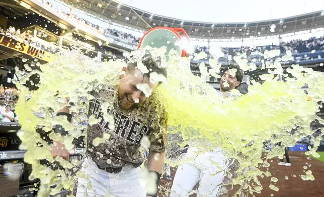 San Diego Padres' Jake Cronenworth, left, is doused after hitting a walkoff single during the 10th inning of a baseball game against the Texas Rangers, Friday, July 4, 2025. (AP Photo/Denis Poroy)