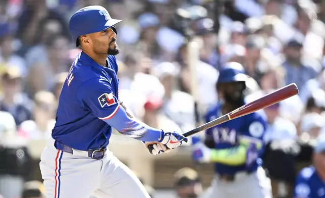 Texas Rangers' Marcus Semien hits an RBI double during the third inning of a baseball game against the San Diego Padres, Friday, July 4, 2025. (AP Photo/Denis Poroy)
