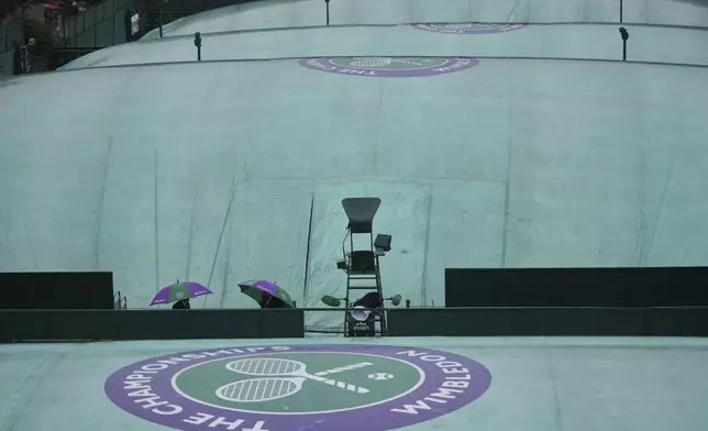 The courts remain covered as rain falls on day three at the Wimbledon Tennis Championships in London, Wednesday, July 2, 2025. (AP Photo/Alastair Grant)