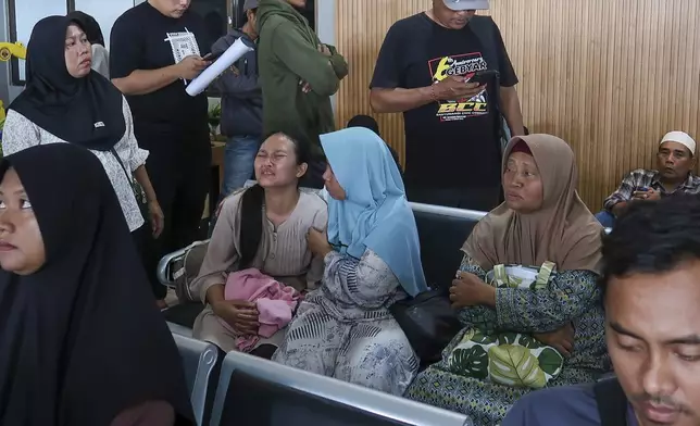 A passenger's relative weeps after a ferry carrying dozens of passengers sank near the resort island of Bali, at Ketapang Port in Bayuwangi, East Java, Indonesia, Thursday, July 3, 2025. (AP Photo/Andur)