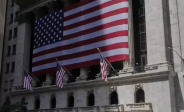 A vendor displays souvenirs on the street in front of the New York Stock Exchange in New York, Monday, July 14, 2025. (AP Photo/Seth Wenig)