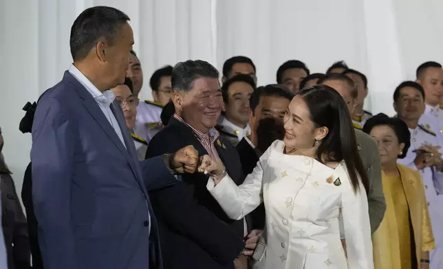 FILE - Thailand's former Prime Minister Srettha Thavisin, left, exchanges a fist bump with new Prime Minister Paetongtarn Shinawatra after Paetongtarn received a royal letter of endorsement for the post at the Pheu Thai party headquarters in Bangkok, Thailand on Aug. 18, 2024. (AP Photo/Sakchai Lalit, File)