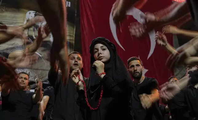 Shiite faithful Muslims attend an Ashoura procession in Istanbul, Turkey, Friday, July 4, 2025. Shiites mark Ashoura, the tenth day of the month of Muharram, to commemorate the Battle of Karbala when Imam Hussein, a grandson of Prophet Muhammad, was killed.(AP Photo/Khalil Hamra)