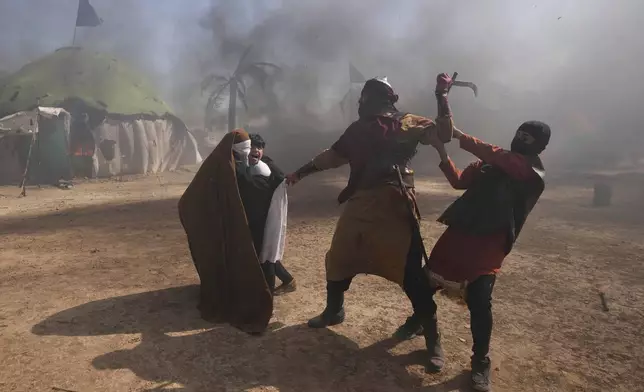 Shiite Muslims re-enact the seventh century battle of Karbala during activities marking the holy day of Ashoura, the annual Shiite Muslim commemoration marking the death of Imam Hussein, the grandson of the Prophet Muhammad, in the Shiite neighborhood of Sadr City, Baghdad, Iraq, Sunday, July 6, 2025. (AP Photo/Hadi Mizban)