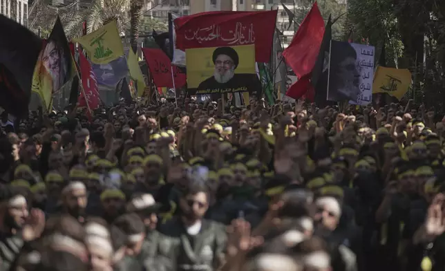 Hezbollah supporters raise their hands and beat their chests as they march during Ashoura, the Shiite Muslim commemoration marking the 7th-century death of Imam Hussein, the grandson of the Prophet Muhammad, at the Battle of Karbala, in the southern suburbs of Beirut, Lebanon, Sunday, July 6, 2025. (AP Photo/Hassan Ammar)
